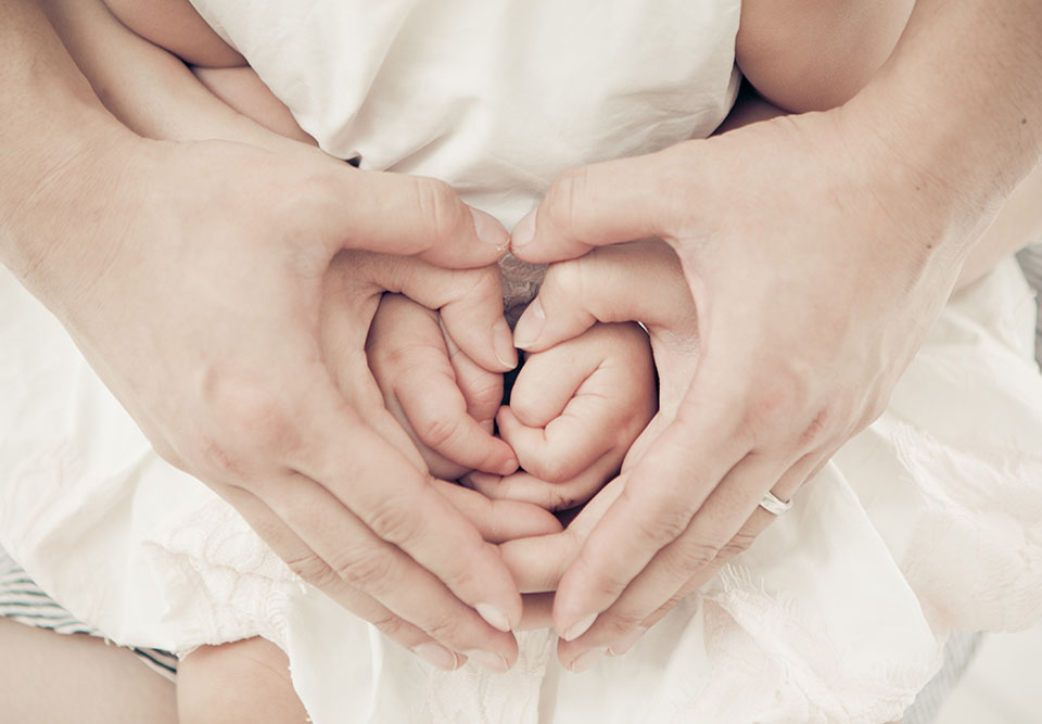 mothers hand on babies hand photo